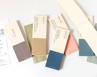 Può includere: Sei segnalibri di diversi colori con testo giapponese. I segnalibri sono tutti rettangolari e hanno una metà superiore bianca e una metà inferiore colorata. Il testo sui segnalibri è in nero.