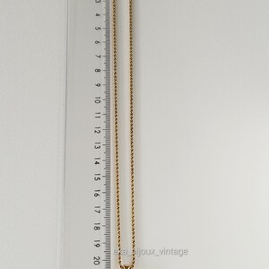 K&ouml;nnte beinhalten: Eine goldene Kettenkette mit einem vierbl&auml;ttrigen Kleeblatt-Anh&auml;nger, der mit klaren Strasssteinen besetzt ist. Die Kette ist 22 cm lang.