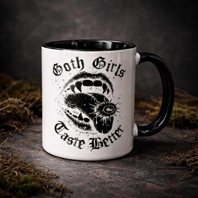 Gothic coffee mug with “Goth Girls Taste Better” text and vampire mouth design on black handle ceramic mug