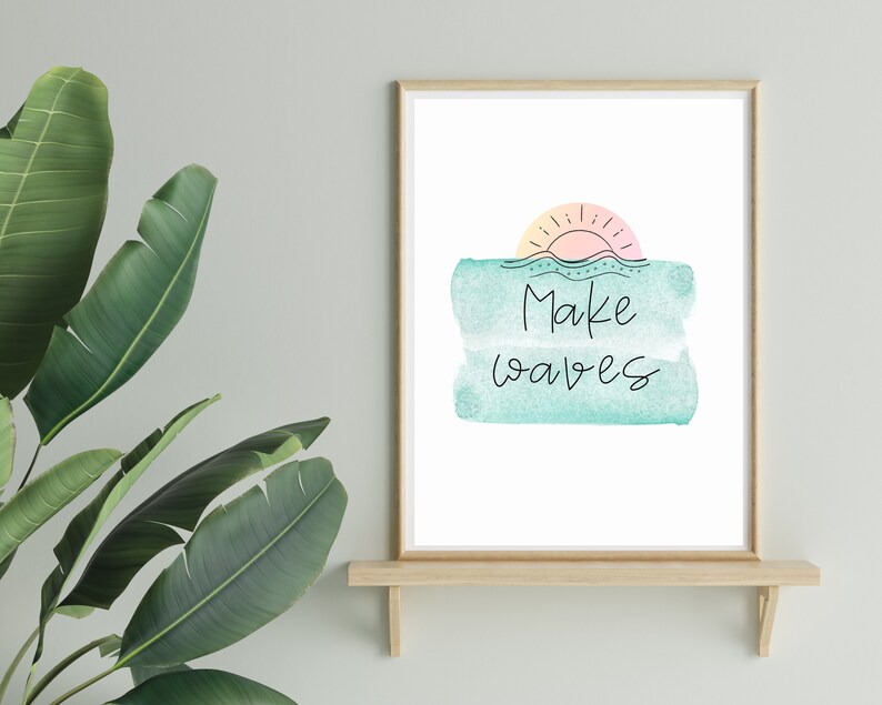 May include: A framed print with a watercolor background of a sunset over the ocean. The text "Make waves" is written in black cursive on the print.