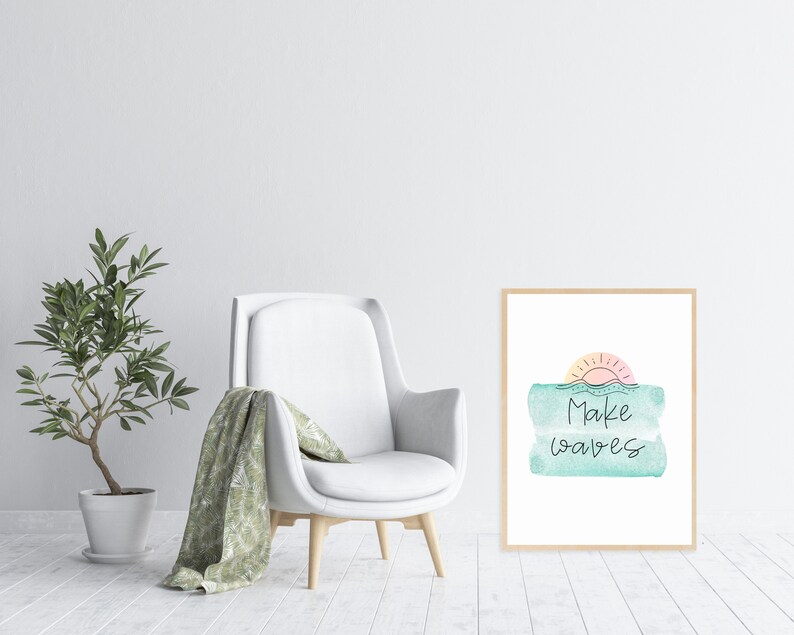 May include: A framed print with a watercolor design of a sunset over the ocean. The text "Make waves" is written in black cursive script.