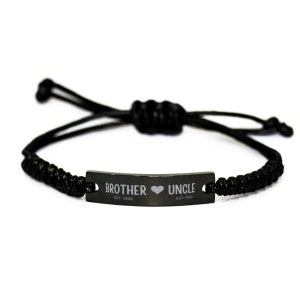 May include: Black adjustable bracelet with a black metal tag that reads "Brother Est. 1986" with a heart symbol and "Uncle Est. 2023".