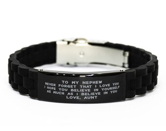 May include: Black silicone bracelet with a stainless steel clasp. The bracelet features engraved text that reads "TO MY NEPHEW NEVER FORGET THAT I LOVE YOU I HOPE YOU BELIEVE IN YOURSELF AS MUCH AS I BELIEVE IN YOU LOVE, AUNT."