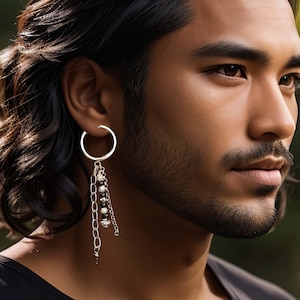 May include: A silver hoop earring with a dangling chain and black beads. The chain has a silver charm at the end.
