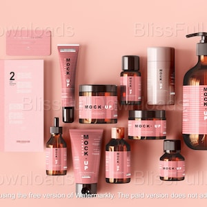 May include: A collection of cosmetic product mockups in brown glass bottles and jars with pink labels, arranged on a pink background. Includes a brochure and a tube of cream. The text "MOCK-UP" is visible on the labels.