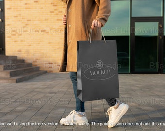 Maquette de sac à provisions de luxe, modèle PSD de marque élégante pour la vitrine d'emballage de vente au détail de mode - Modèle tenant une maquette de sac en papier luxueux