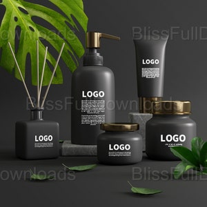 以下が含まれることがあります： 黒と金のバスルーム製品のセットで、各ボトルに「LOGO」の文字が書かれています。製品には、ポンプボトル、ローションチューブ、クリームジャー、ディフューザーが含まれています。製品は、緑の葉のある黒い表面に配置されています。