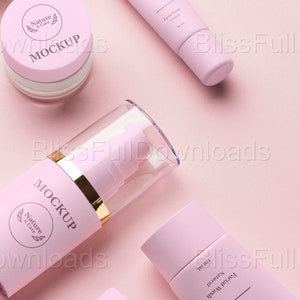 May include: A collection of pink cosmetic product mockups, including a jar, a tube, and bottles with pump dispensers. The products feature the text "MOCKUP" and "Beauty Care" with a minimalist design on a light pink background.