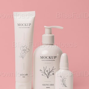 May include: Three white bottles of skincare products on a pink background. The bottles are labeled "MOCKUP" and "SKINCARE 80ML".