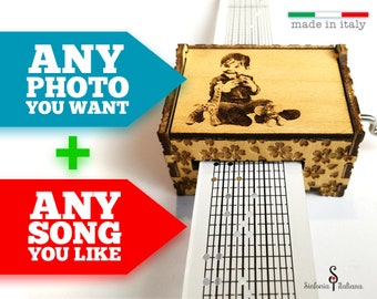 May include: A wooden music box with a personalized photo of a child and a music sheet. The music box is made in Italy and says "Sinfonia Italiana".