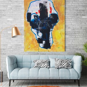 May include: Abstract expressionist painting with a yellow background and a central black and white form outlined in blue. The artwork hangs above a light blue sofa with zebra-print pillows, complemented by an orange rug and a gold floor lamp.