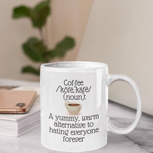 May include: White ceramic coffee mug with a handle. The mug features the word "Coffee" with phonetic pronunciation and the phrase "A yummy, warm alternative to hating everyone forever."
