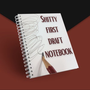 May include: A spiral-bound notebook with the words "SHITTY FIRST DRAFT NOTEBOOK" printed in dark red. A pencil is positioned as if writing on the page, with scribbled lines above. The background is a mix of red and black.
