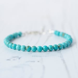 May include: A turquoise beaded bracelet with a silver clasp.