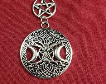 May include: A silver necklace with a triple moon pendant and a pentacle charm. The pendant features a tree of life design with three crescent moons and a pentacle in the center. The charm is a simple pentacle.