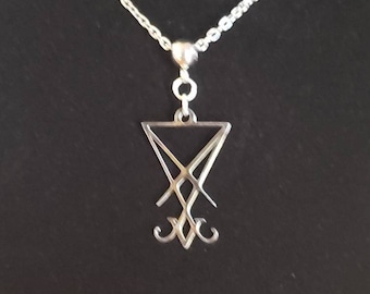 May include: A silver chain necklace with a silver pendant featuring the sigil of the demon Baphomet. The pendant is a stylized inverted pentagram with two horns at the top.