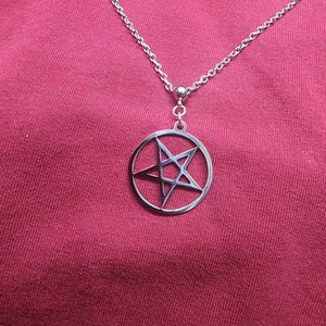 May include: A silver chain necklace with a pendant featuring a pentagram inside a circle.