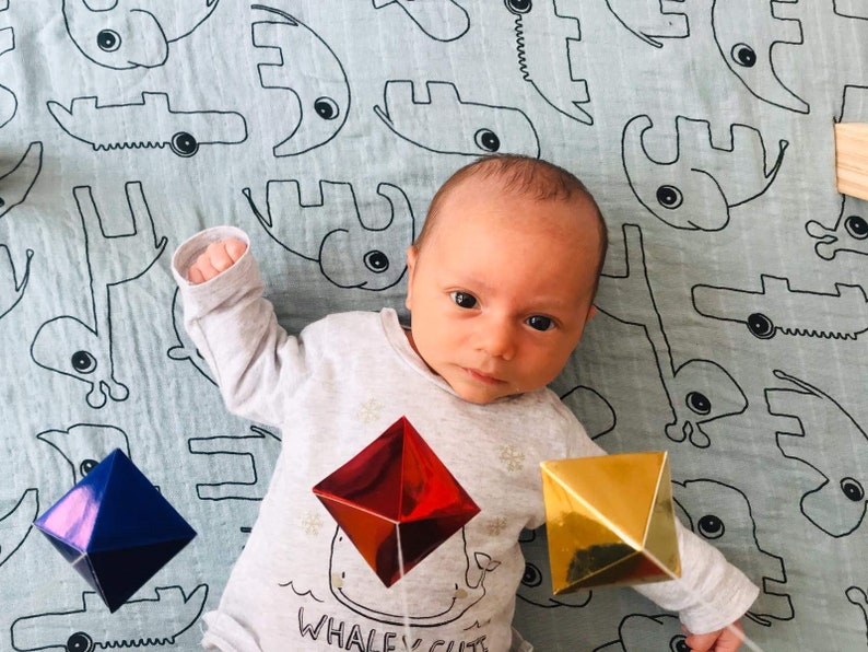 A baby boy with the DIY Montessori Octahedron baby mobile