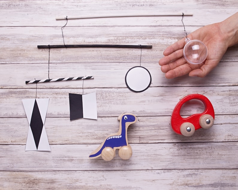 Montessori Munari mobile - the plastic ball is held in a hand for scale