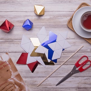 The cut out shapes of the DIY Montessori Octahedron baby mobile and some props
