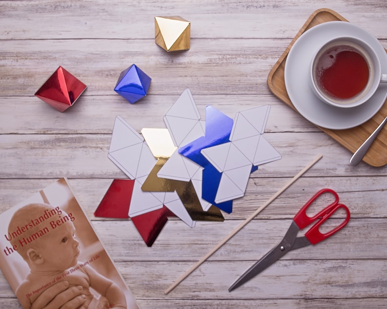 The cut out shapes of the DIY Montessori Octahedron baby mobile and some props