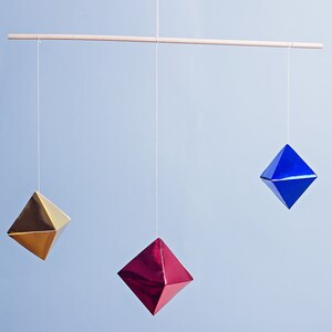 The DIY Montessori Octahedron mobile in front of a blue background.