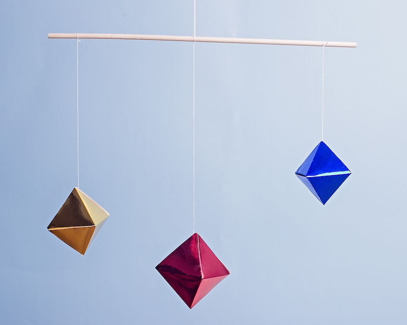 The DIY Montessori Octahedron mobile in front of a blue background.