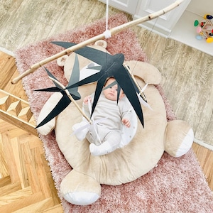 Baby gazing at the slowly moving swallow figures, developing early visual tracking and concentration.