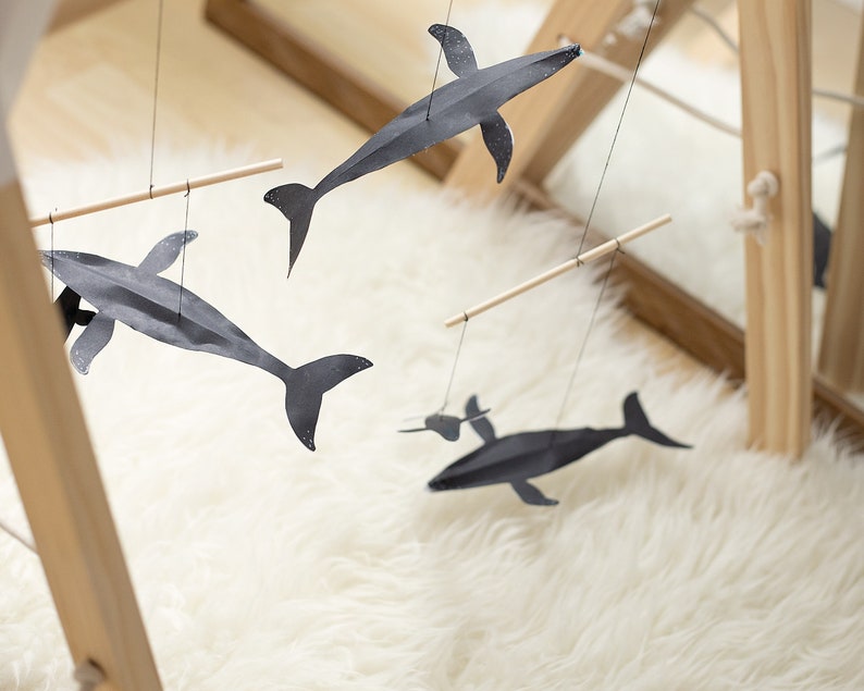 DIY Montessori Whale Mobile with black and white animal shapes hanging above baby play area or changing table
