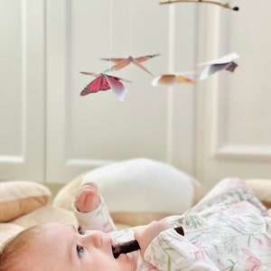 Butterfly paper mobile hanging over a play mat, safely out of baby’s reach