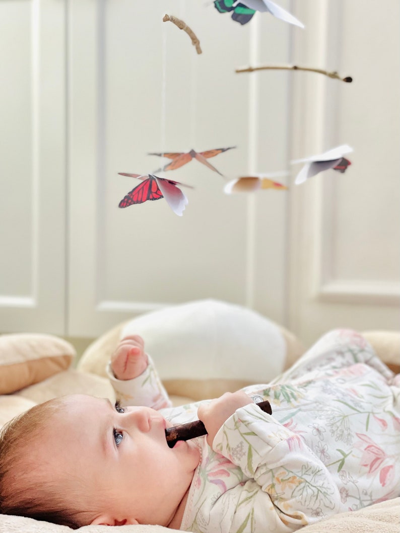 Butterfly paper mobile hanging over a play mat, safely out of baby’s reach