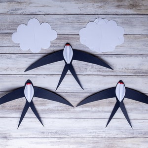 DIY Montessori Swallows Mobile – five black and white swallow elements displayed on a wooden background, ready for assembly