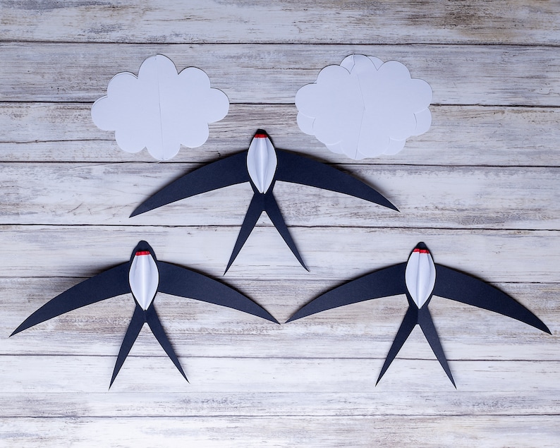 DIY Montessori Swallows Mobile – five black and white swallow elements displayed on a wooden background, ready for assembly