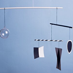 Montessori Munari mobile - black and white baby mobile hanging in front of a blue background