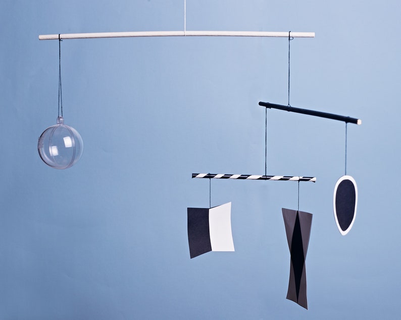 Montessori Munari mobile - black and white baby mobile hanging in front of a blue background