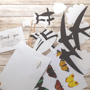DIY animal mobile kit contents displayed, including templates, dowels, thread, and printed instruction