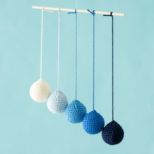 Crocheted Gobbi mobile in front of a blue background