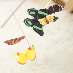 Butterfly mobile hanging in a softly lit nursery corner as Montessori-style decor