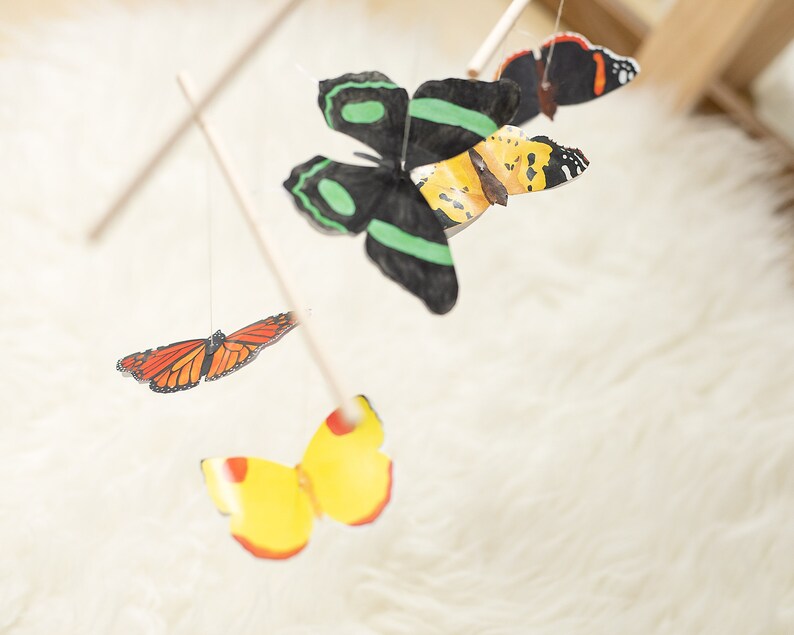 Butterfly mobile hanging in a softly lit nursery corner as Montessori-style decor