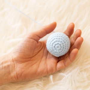 One ball of the Crocheted Gobbi mobile in hand for scale