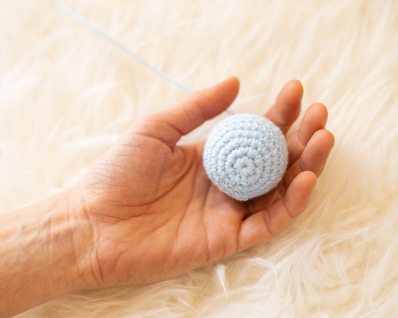 One ball of the Crocheted Gobbi mobile in hand for scale