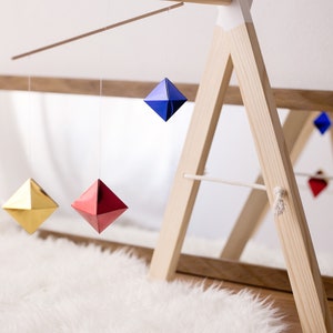 The Montessori Octahedron mobile in front of a mirror, hanging on a mobile stand.