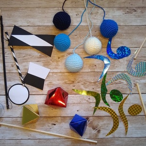 The ready-made mobiles of the DIY Montessori crocheted mobile set, lying on a wooden surface