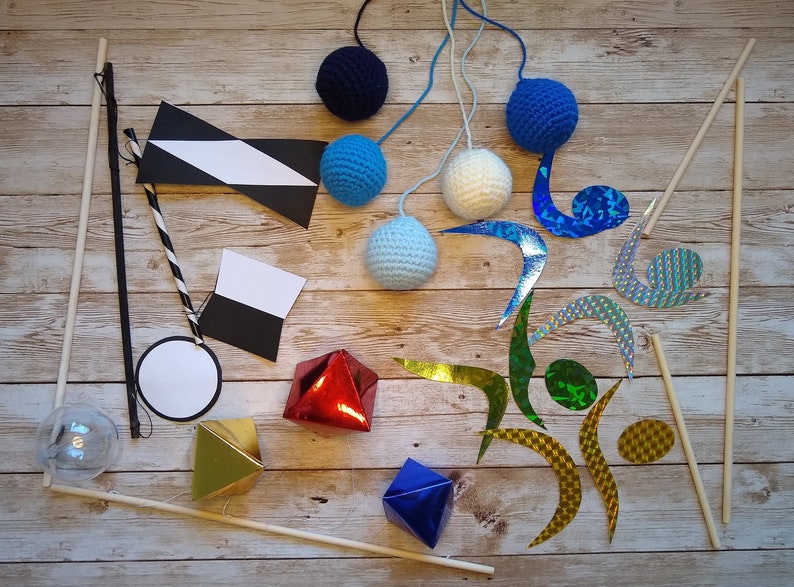 The ready-made mobiles of the DIY Montessori crocheted mobile set, lying on a wooden surface