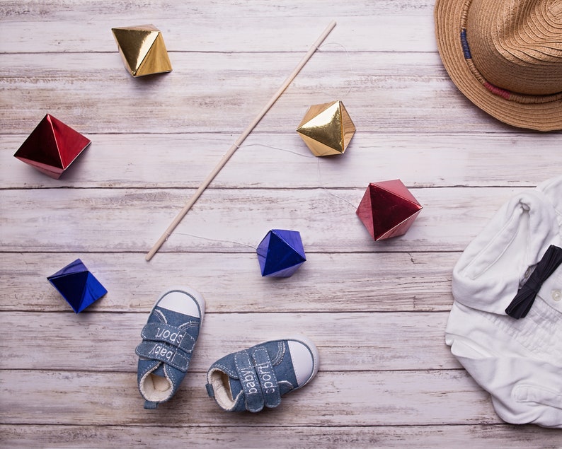 The DIY Montessori Octahedron baby mobile with some baby clothes for props