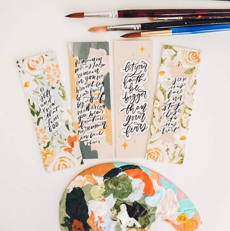 Puede incluir: Tres marcap&aacute;ginas con estampado floral y citas inspiradoras escritas en tinta negra. Las citas son "Estad quietos y sabed que yo soy Dios", "Permaneced en m&iacute;, como yo tambi&eacute;n permanezco en vosotros. Ning&uacute;n p&aacute;mpano puede producir fruto por s&iacute; mismo, as&iacute; como tampoco vosotros pod&eacute;is producir fruto si no permanec&eacute;is en m&iacute;. Juan 15:4-5", y "Que tu fe sea m&aacute;s grande que tus miedos".