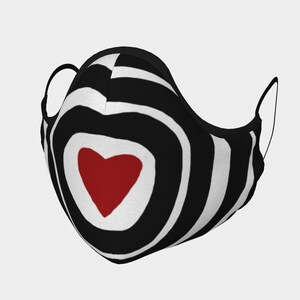 May include: Black and white striped face mask with a red heart in the center. The mask has a black elastic band.