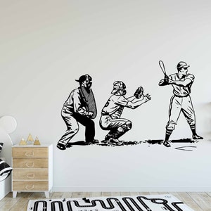 Op de afbeelding: Zwart-witte illustratie van drie honkballers. Een slagman zwaait met een knuppel, een catcher hurkt en een scheidsrechter staat achter de catcher.