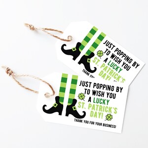 May include: Two green and white striped gift tags with black leprechaun shoes and shamrocks. The text on the tags reads "Just popping by to wish you a lucky St. Patrick's Day!" and "Thank you for your business!"