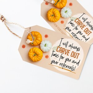 May include: Two beige gift tags with the text "I will always CARVE OUT time for you and your referrals!" are shown. The tags are decorated with small orange and white pumpkins and orange flower accents. A twine string is attached.